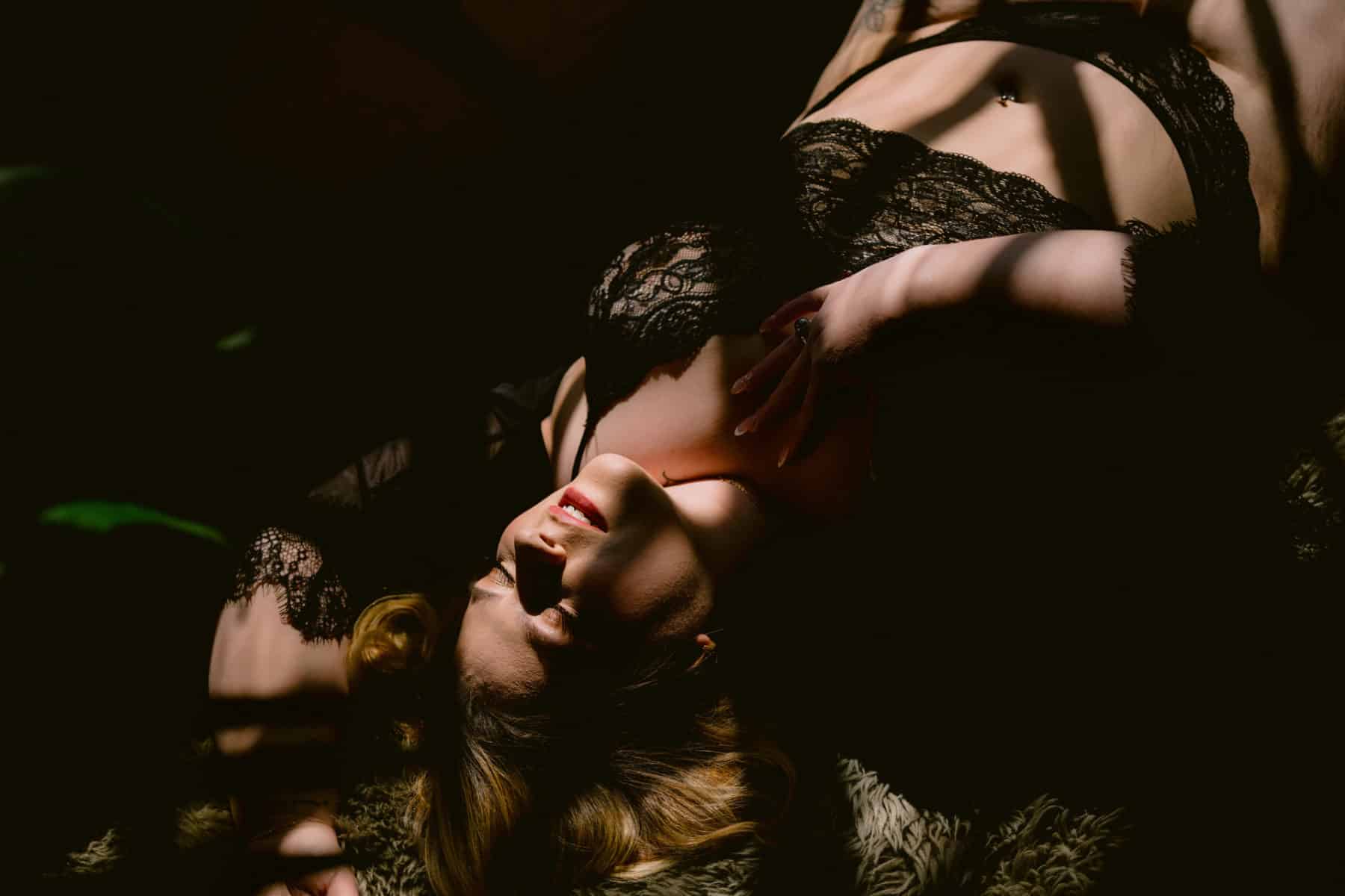 Window lit boudoir, dramatic lighting, woman on her back lying in the broken up sun light