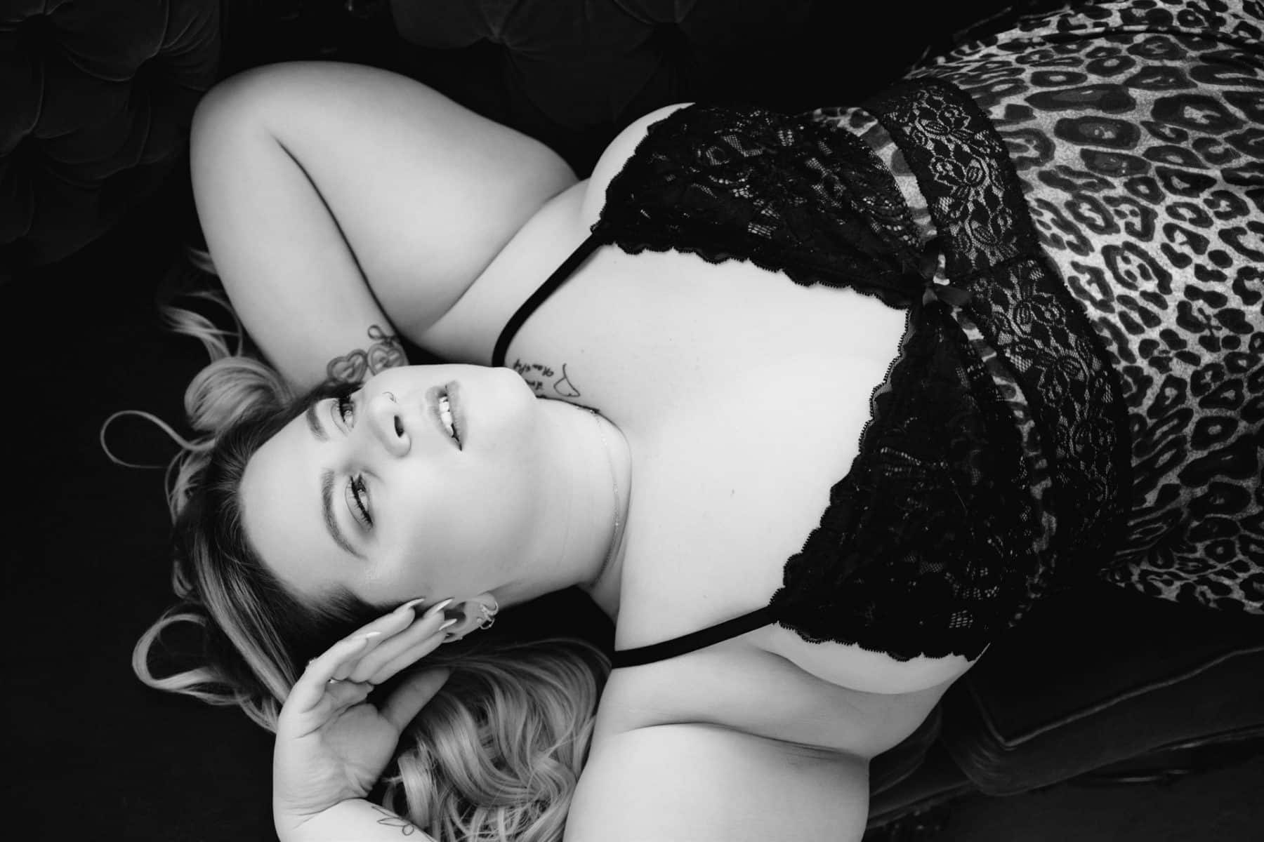 Black and white boudoir photo of plus size woman, from above, in a leopard print nightgown. Philadelphia Boudoir Photographer