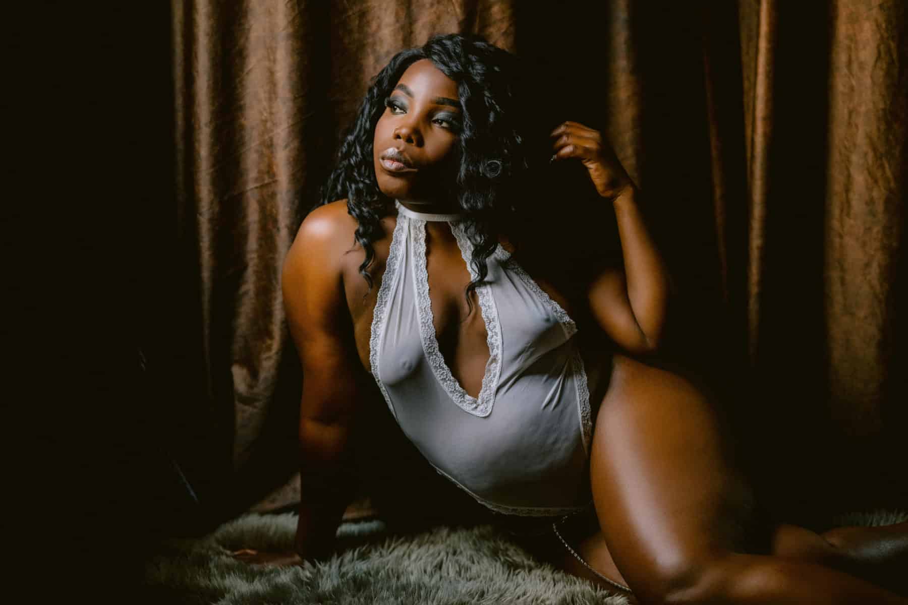 Gorgeous curvy woman of color during boudoir session